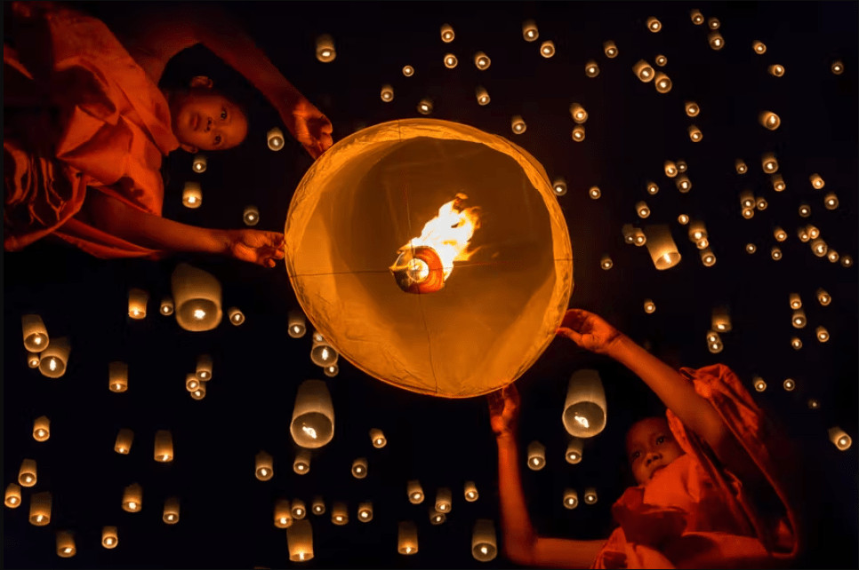 Nybegyndere munke slipper en lanterne under Loi Krathong i Chiang Mai
